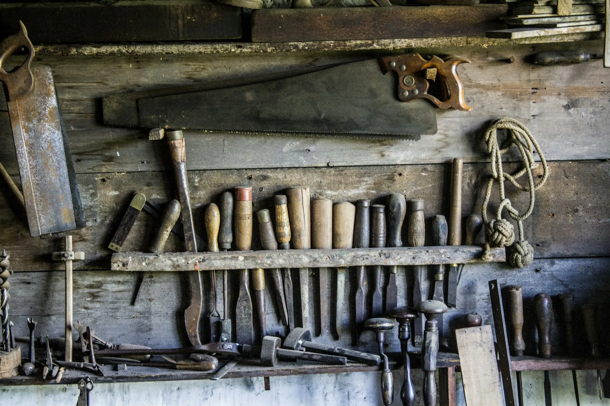 Old hand tools hanging on a workshop wall